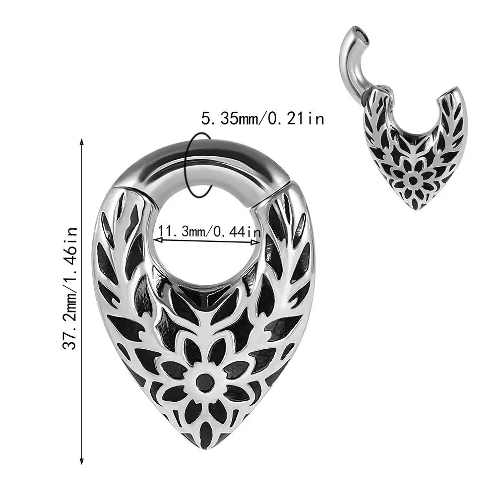 A stainless steel drop-shaped ear extender with totem detailing for 0 gauge stretched earlobes.