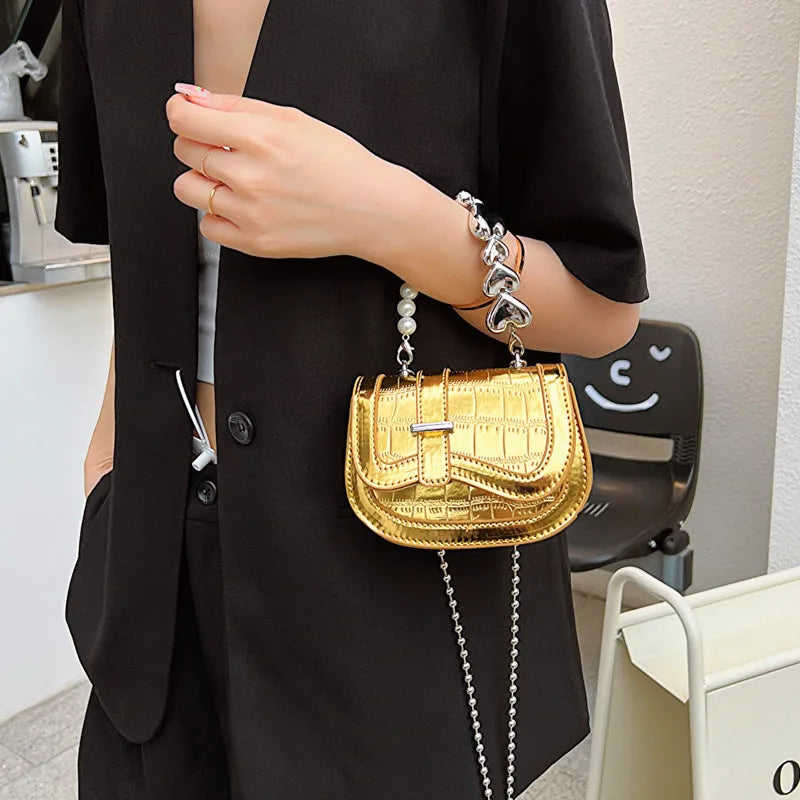 Women's silver mini crossbody bag with a square shape and a single shoulder strap.