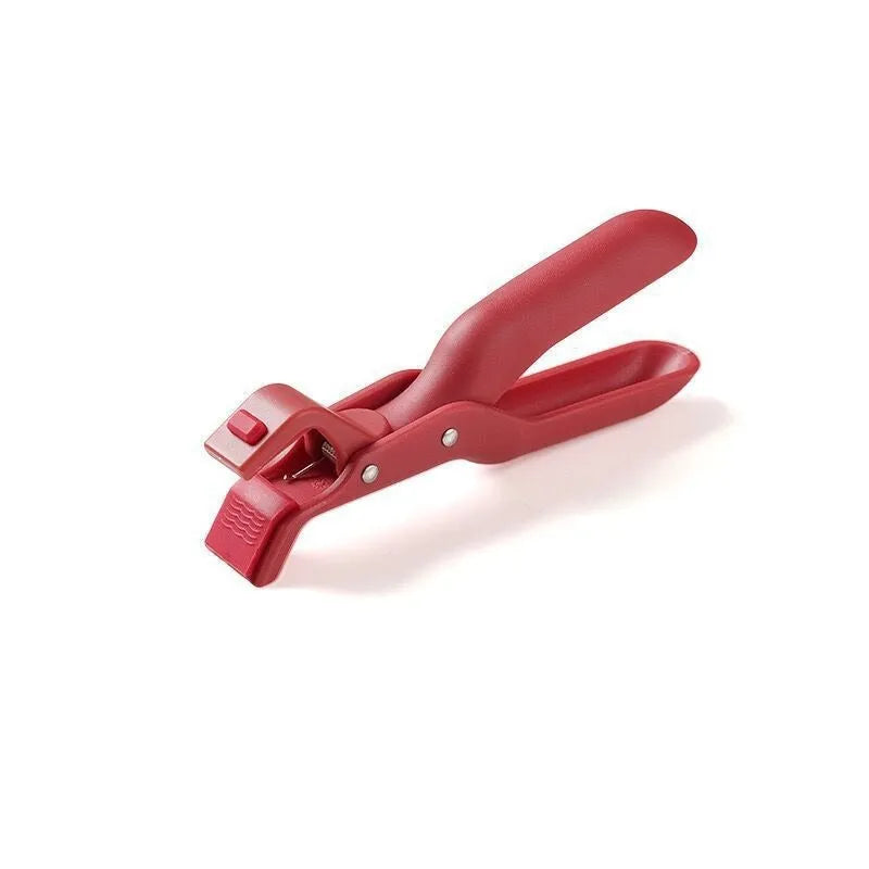 Creative household kitchen silicone anti-scalding clip in carmine colour on a table with a nearby pot