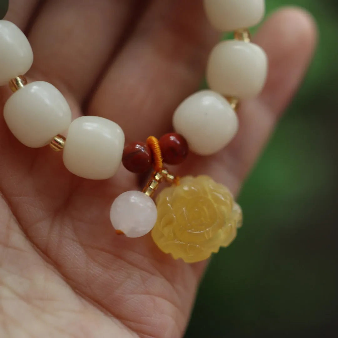 Women's Bodhi root bracelet with gradient white jade beads and a natural beeswax lotus pendant.