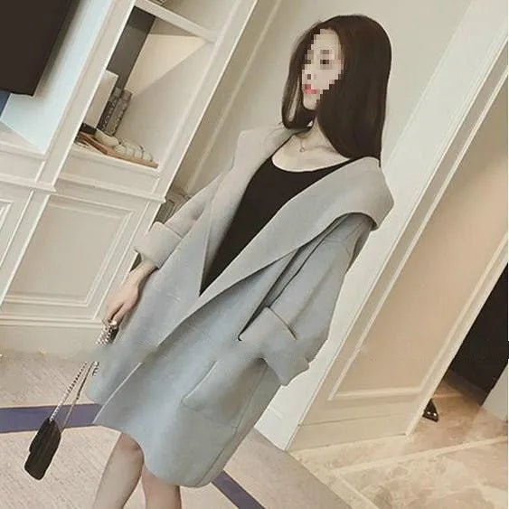 Plus size woman wearing a thin grey cotton coat with lace detail, loose fit long sleeves.