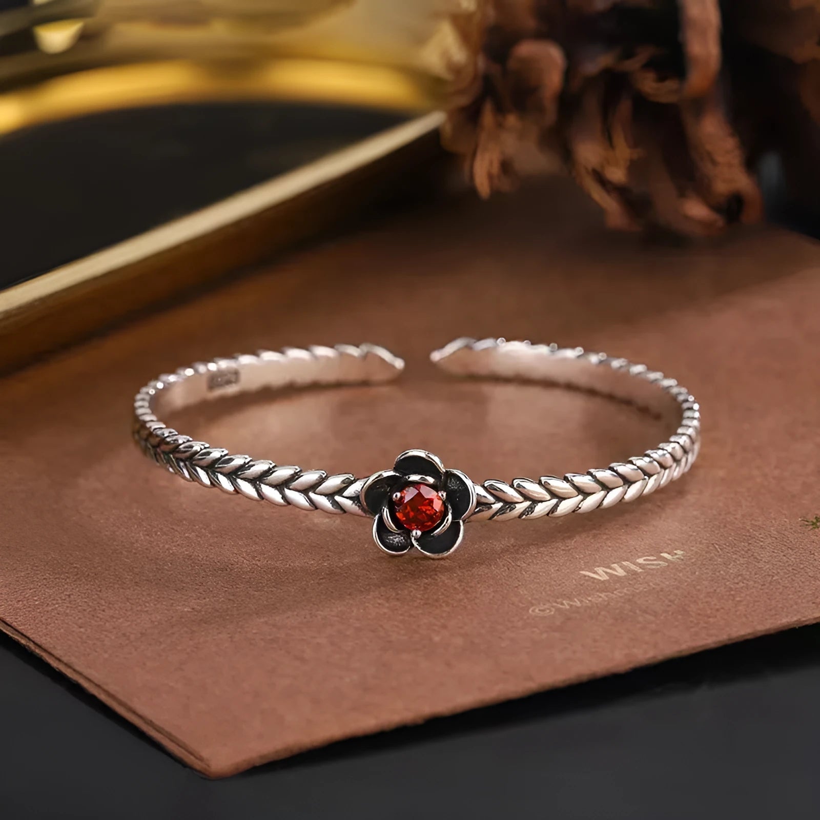 Silver zinc alloy retro bracelet with red zirconium plum flower centrepiece on white background