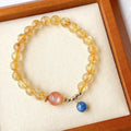 Gold rutilated quartz and sunstone bracelet with round diamond-shaped beads.