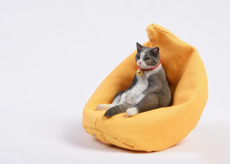 Lazy cat figurine reclining on a sofa, a small resin car dashboard ornament.