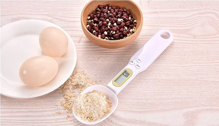Black digital measuring spoon scale showing 0.0g display on LCD screen with 500g capacity