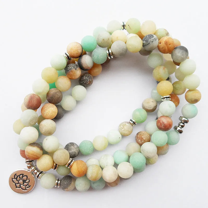 108 bead matte amazonite mala bracelet with lotus Buddha pendant on a surface