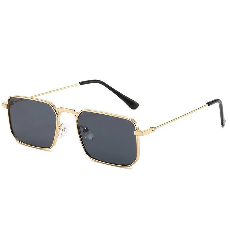 Square-shaped steampunk sunglasses for men with gold frame and grey lenses on a plain background