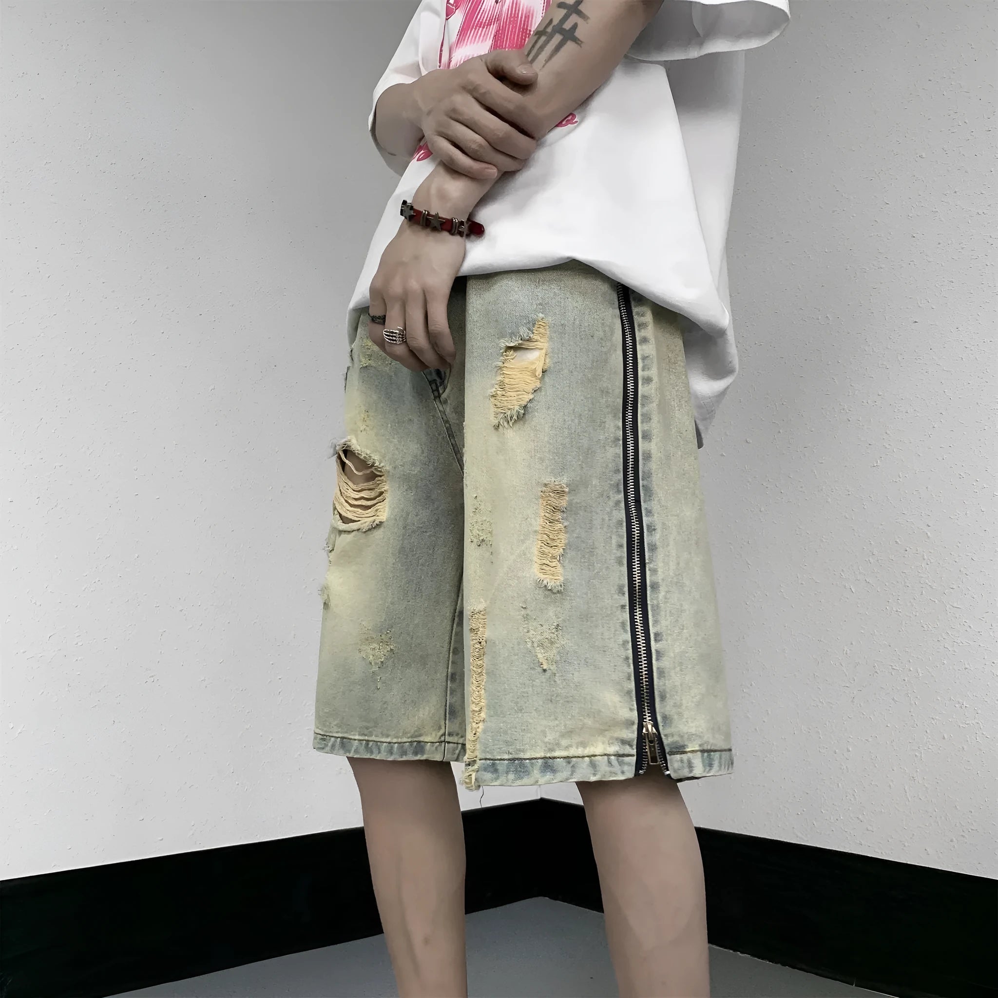 Men's blue denim shorts with yellow mud finish, ripped details, cardigan buttons, and a straight leg opening.