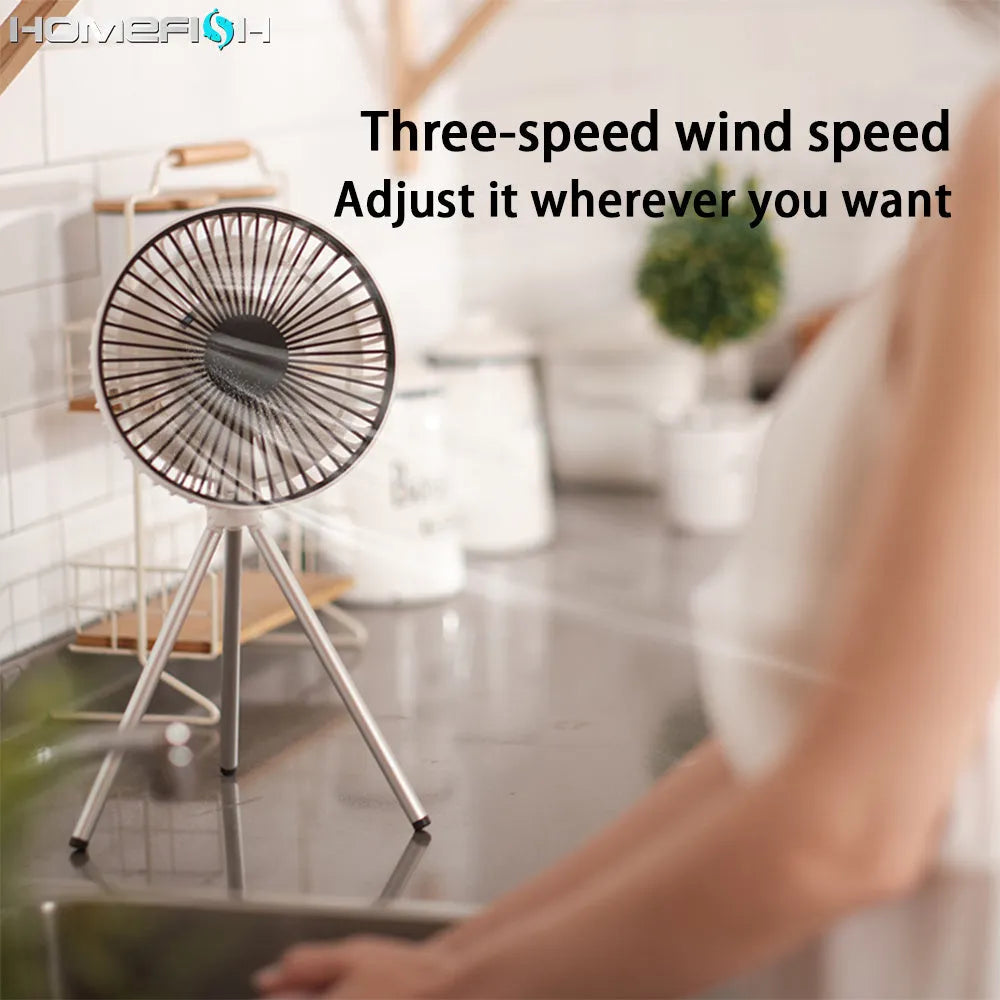 White tripod camping fan on a desk, with USB cable and adjustable speed dial
