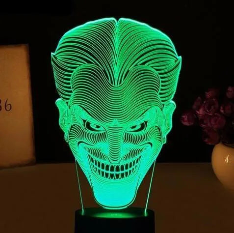 A 3D acrylic LED desk lamp showing multicolour gradient lighting, sitting on its square base with a USB cable.