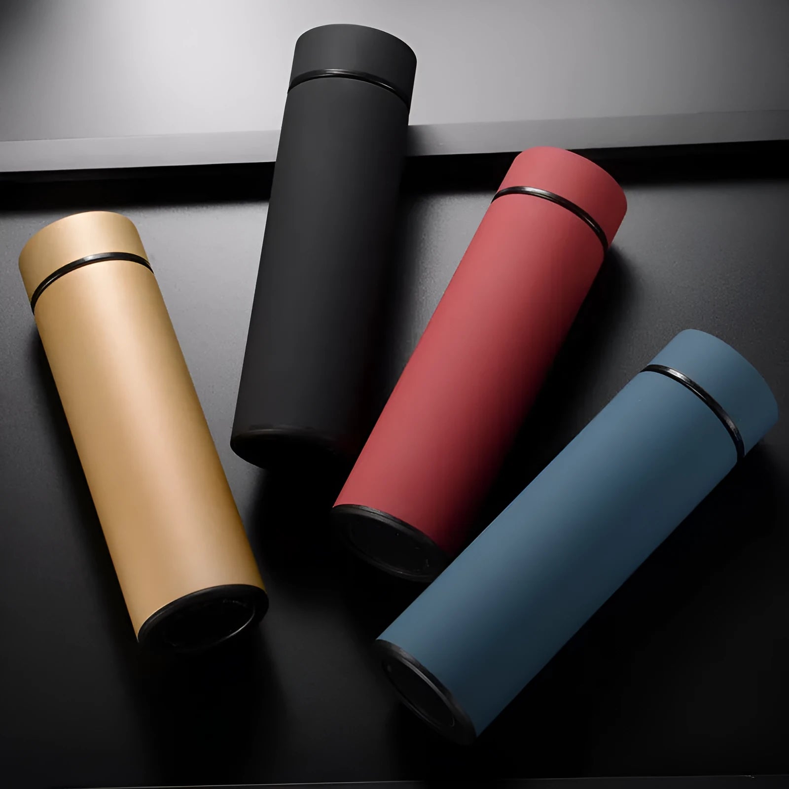 Stainless steel water bottle in black, blue, gold, or red with double wall vacuum insulation and arrow mouth.