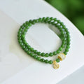 Women's double circle bracelet made from natural Hetian Jade, showing geometric shape and fu character detail.