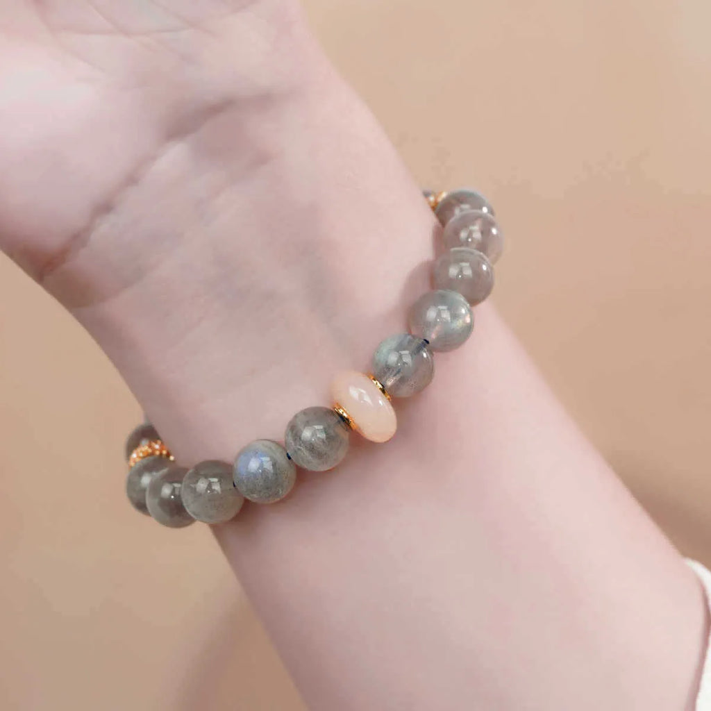 A simple gray moonstone bracelet for women with 8mm round beads on a white background.
