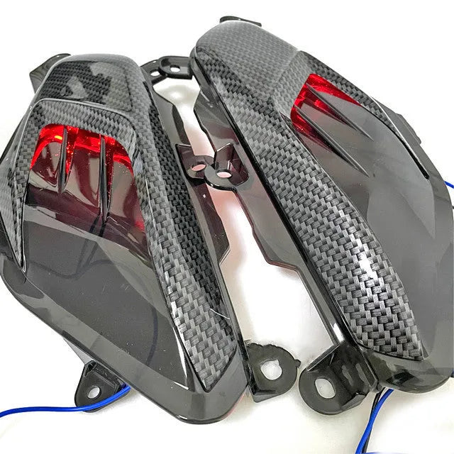 Pair of Yamaha NMAX scooter side lamp units with carbon fibre pattern and blue LED illumination