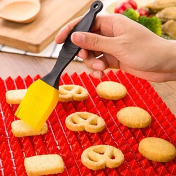 Red silicone pyramid grid cooking mat on a kitchen countertop.