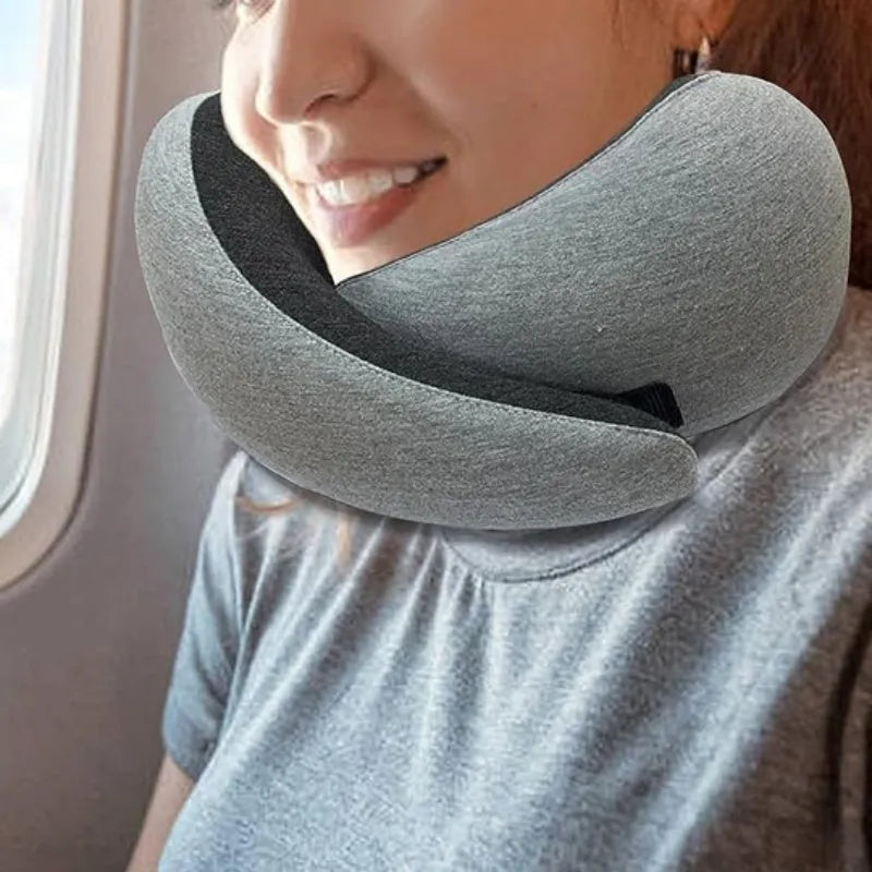 Navy blue U-shaped travel neck pillow rolled up next to its carry bag