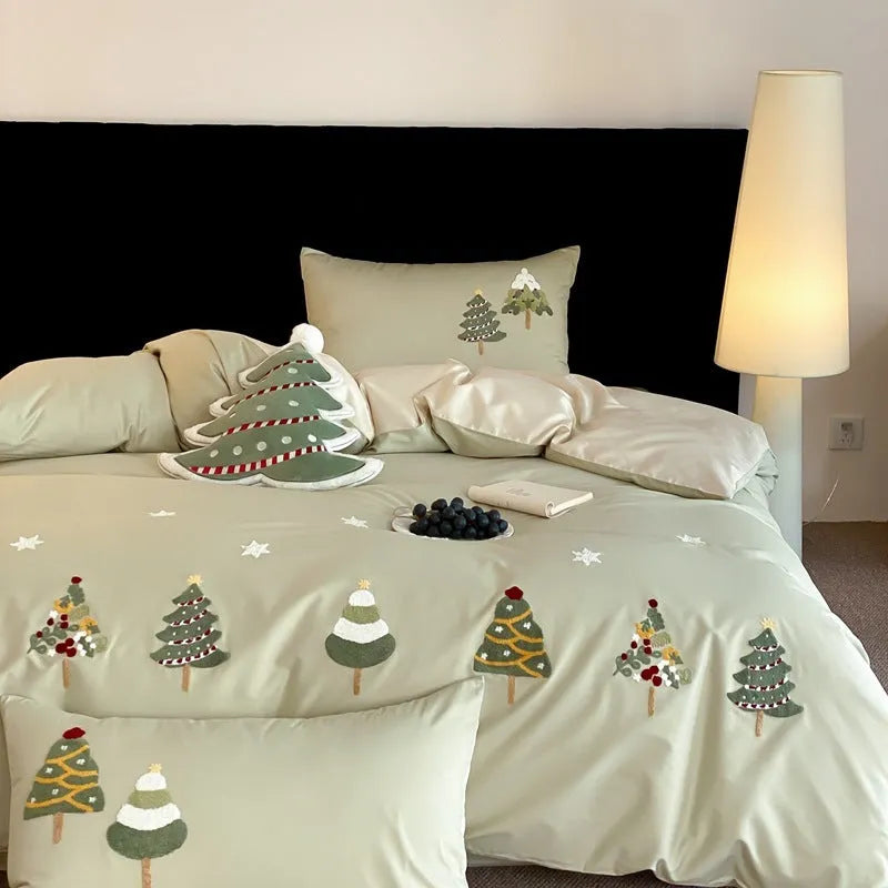 Cream blue cotton duvet cover with embroidered Christmas tree and floral design, laid on a bed with matching pillowcases.