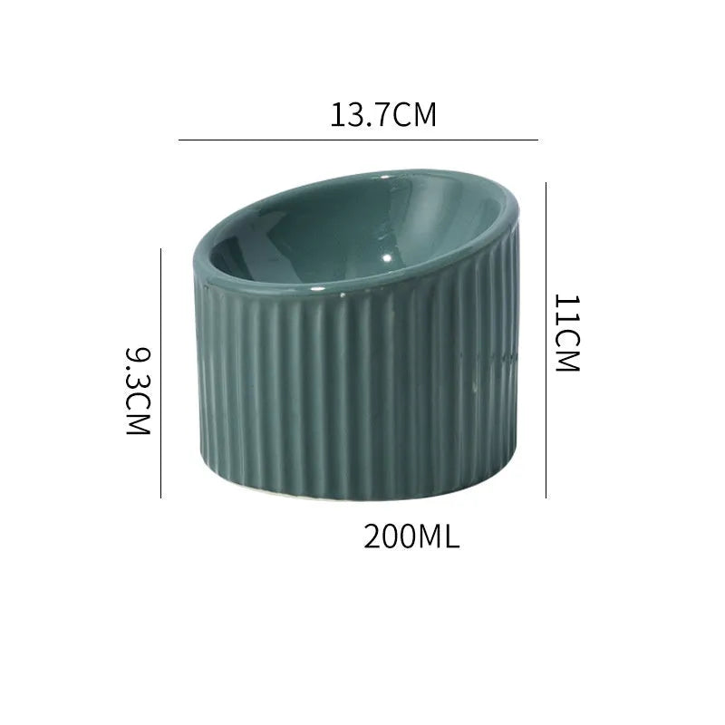 Ceramic elevated cat food bowl in green, showing tilted round dish on a raised stand.