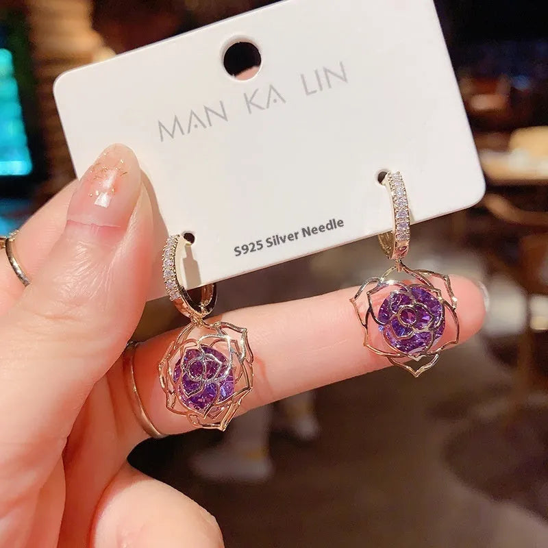 Geometric rose design women's electroplated copper earrings shown in one of the available colour variants.
