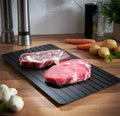 Black aluminium kitchen defrosting tray for thawing frozen meat and food without electricity