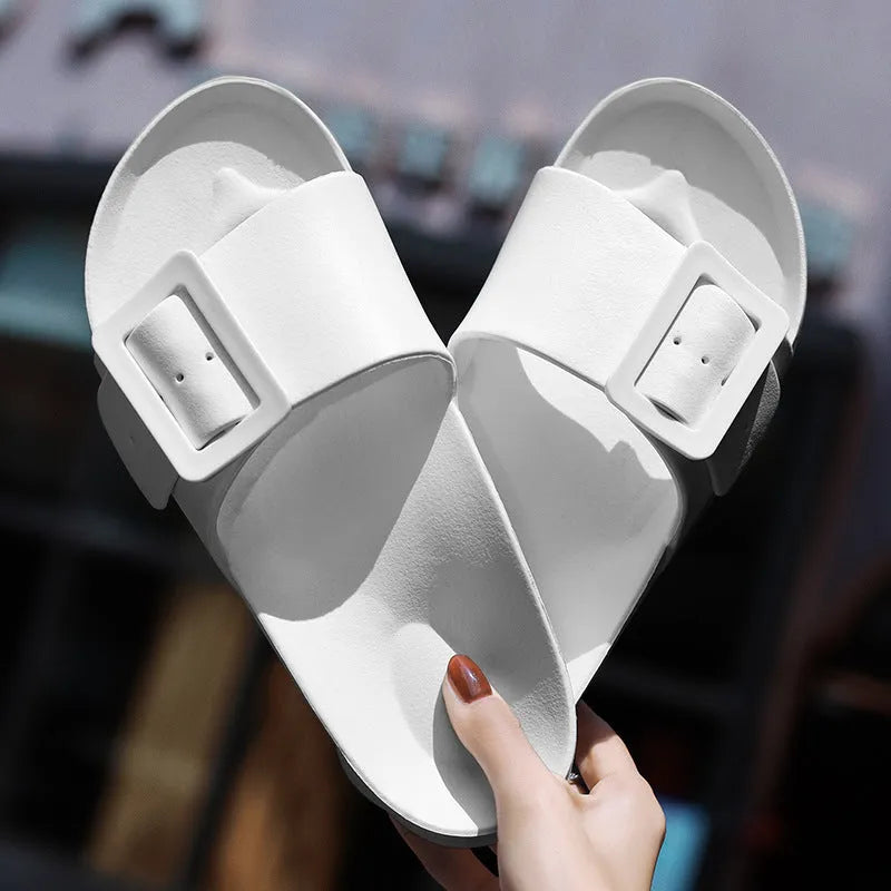 Women's grey blue EVA flip-flop sandals with a silver buckle on the strap, showing flat sole.