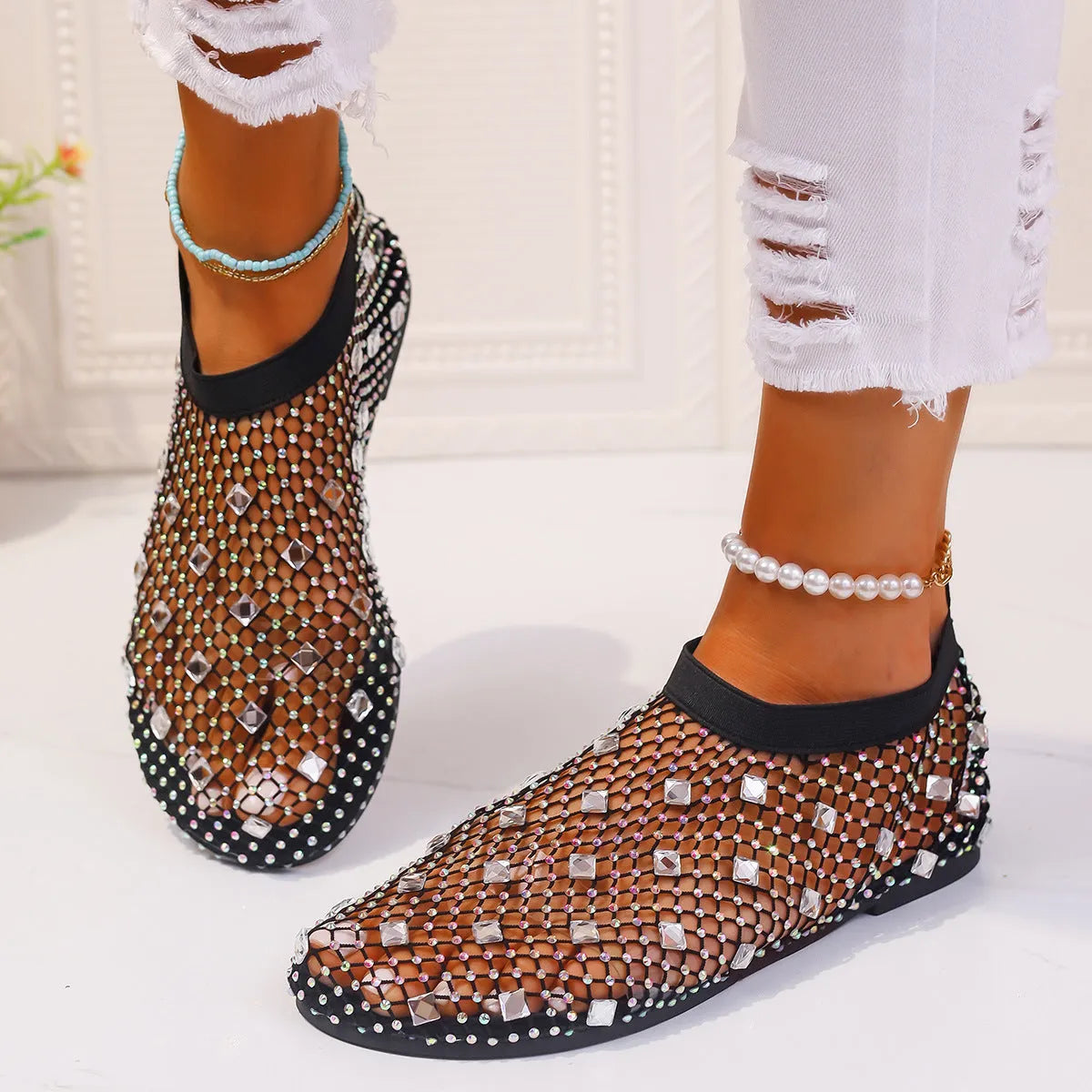 Women's flat mesh sandals with colourful rhinestone detail on a white background.