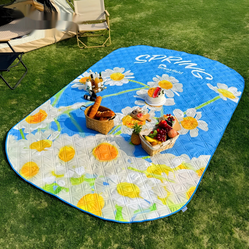 Large rectangular waterproof picnic mat in a seasonal colour, laid out on grass.