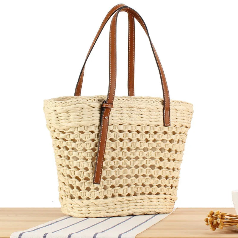 Beige horizontal square woven paper-string shoulder bag showing wide opening and adjustable strap