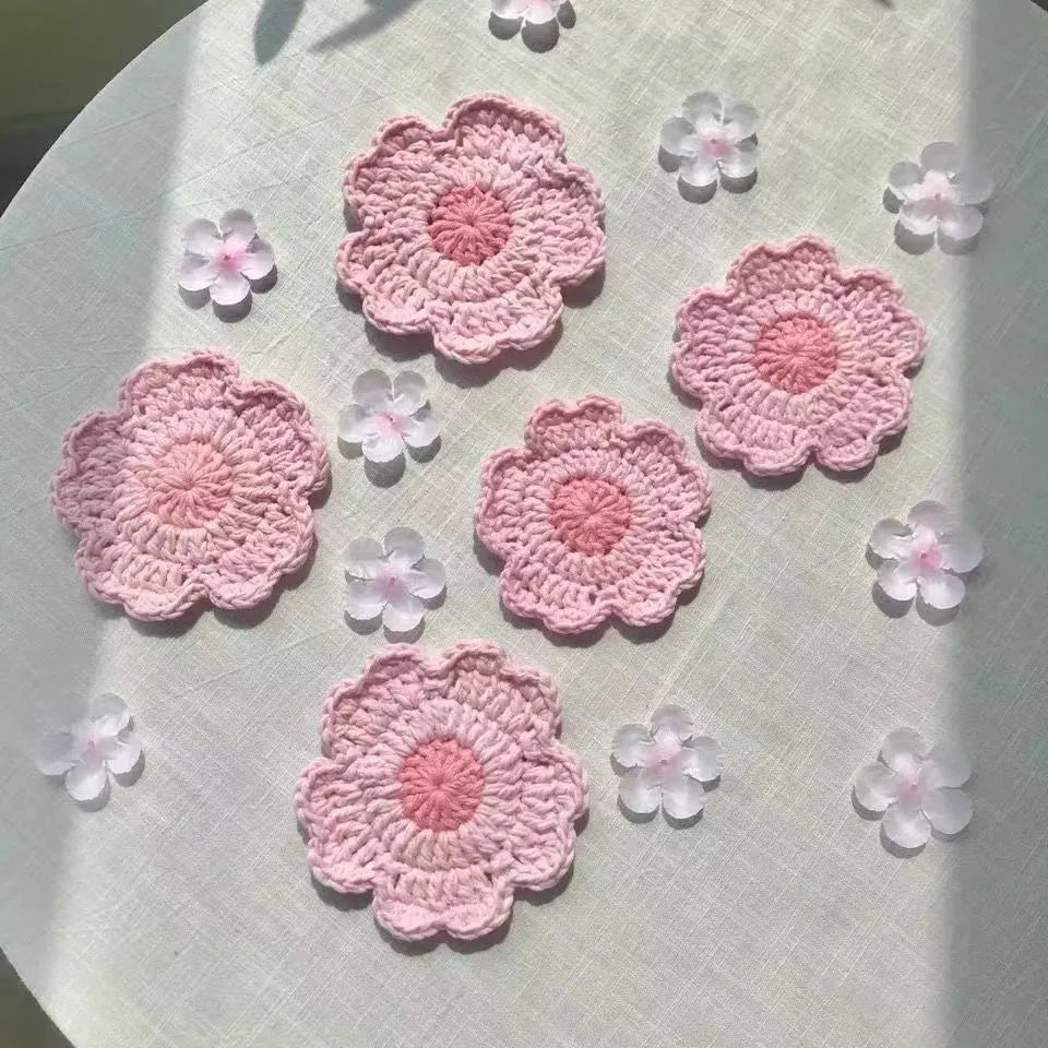 A set of hand-woven decorative wool coasters on a wooden table.