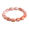 Natural cherry agate barrel bead bracelet with Ruyi charm on a wrist.