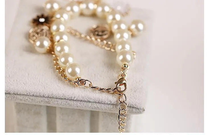 White pearl flower bracelet with simulated pearl beads, floral design, 17cm length, on a soft surface