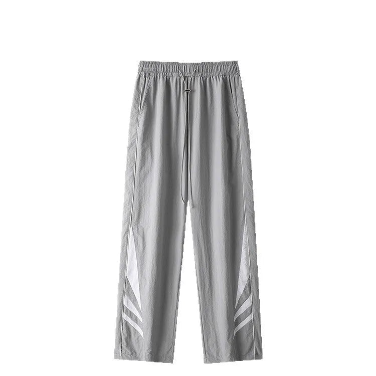A man wearing black straight-leg loose-fit casual sports trousers for summer.