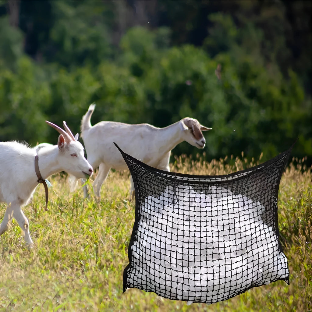 Woven polyethylene rope horse feeding bag in black hanging with hay visible through grid