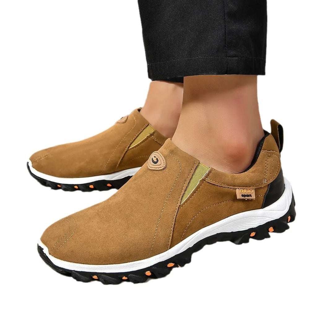 A pair of grey round-toe men's slip-on shoe covers made of PU with a rubber sole.