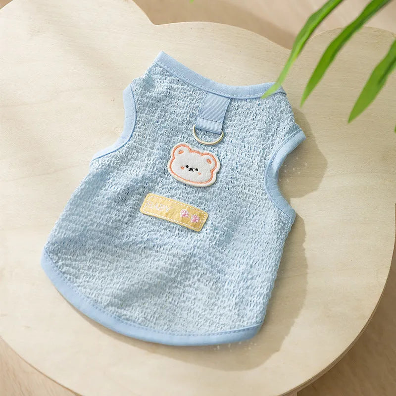 Green knitted cat clothing with a cartoon bear patch, showing hollowed-out breathable fabric.