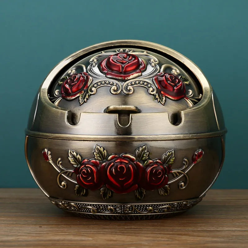 Bronze and red copper alloy decorative ashtray with smoke-extinguishing slot on a table.