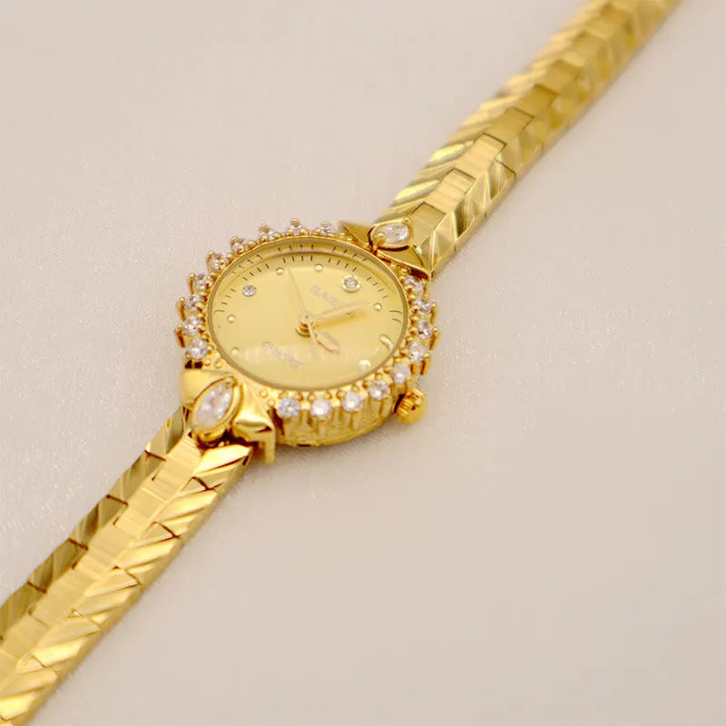 Women's gold vintage style quartz watch with diamond embossed bracelet.