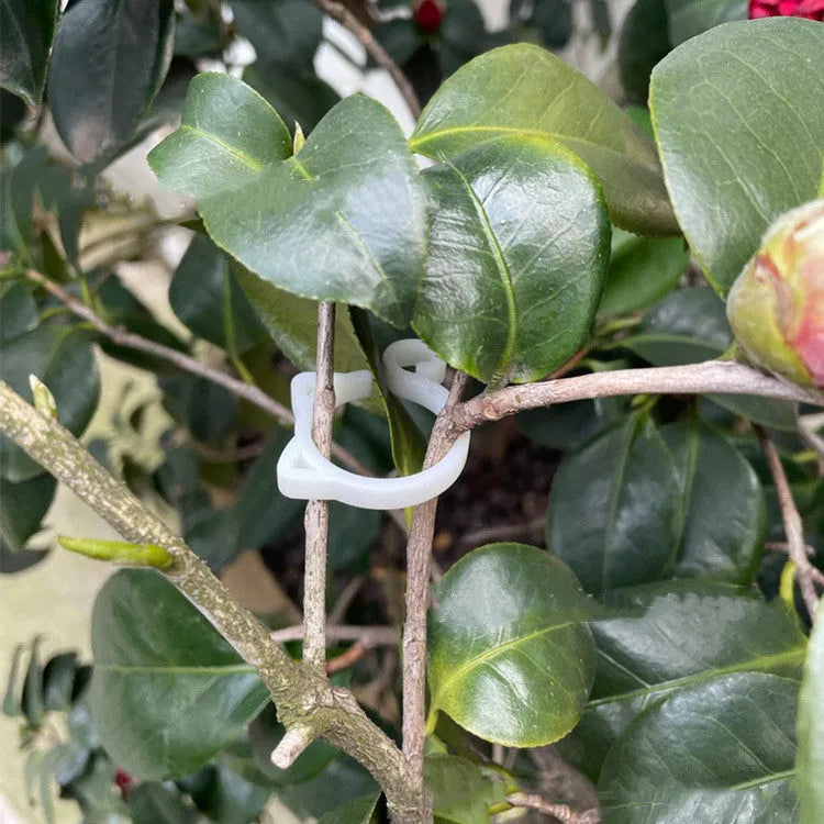 A colourful cat-shaped plastic clip for securing plant stems in the garden.