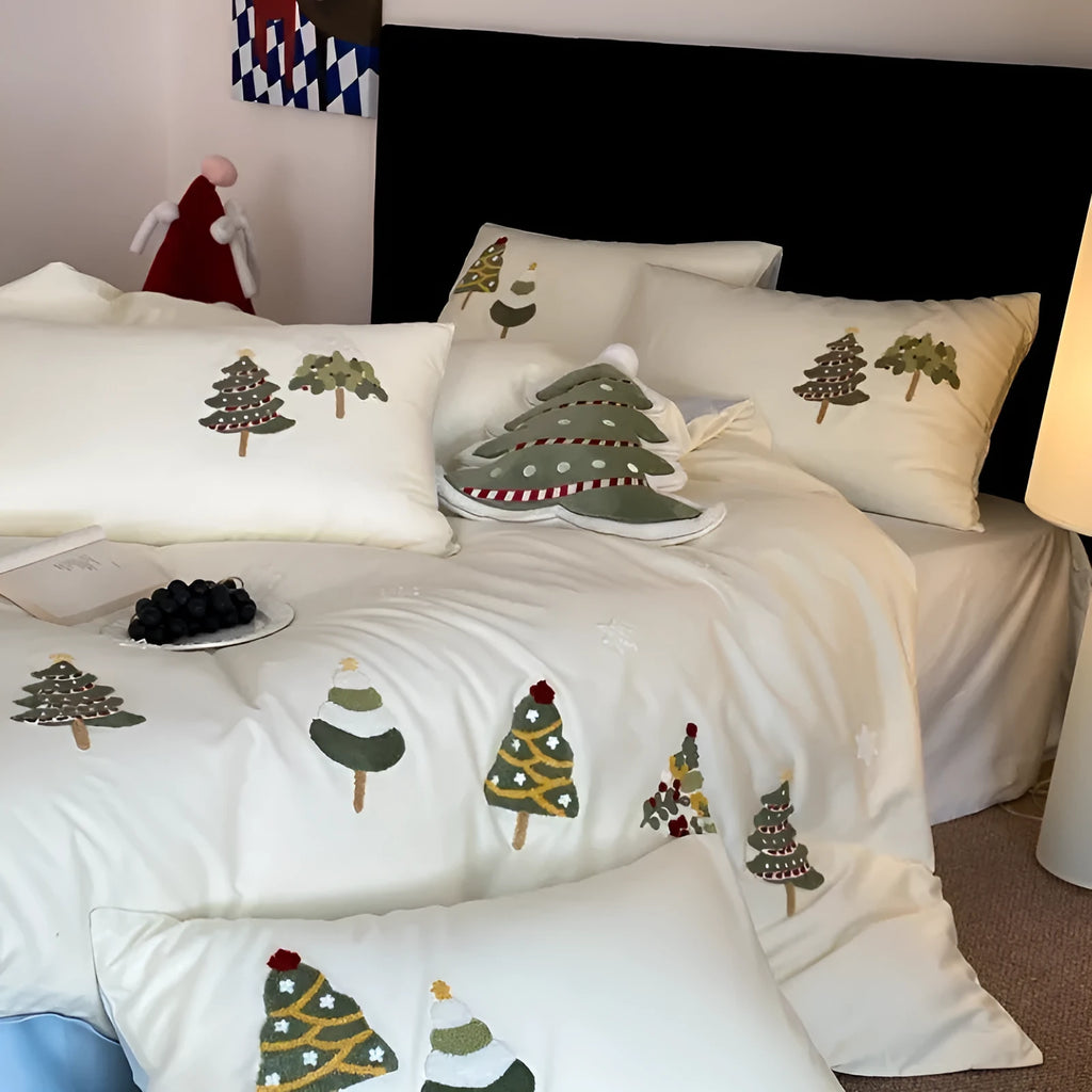 Cream blue cotton duvet cover with embroidered Christmas tree and floral design, laid on a bed with matching pillowcases.