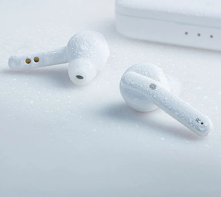 Black and white true wireless stereo earbuds with a compact charging case on a table.