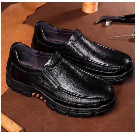 A pair of men's black slip-on business casual shoes made from cowhide leather with a rubber sole.