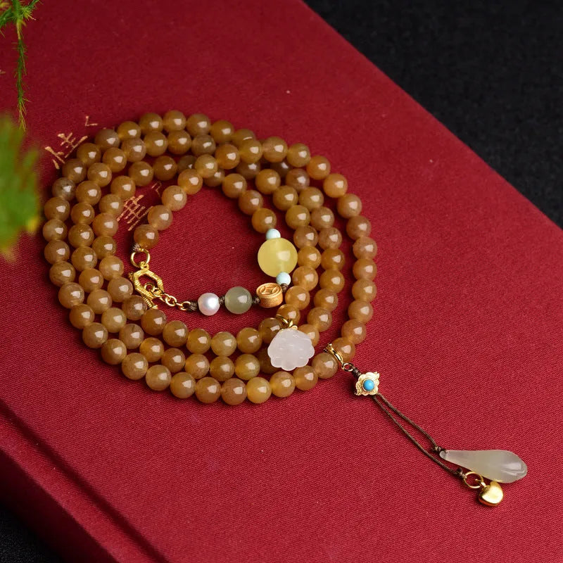 Women's green pine jade and beeswax bracelet with sequin leaves on a 6mm round bead strand.