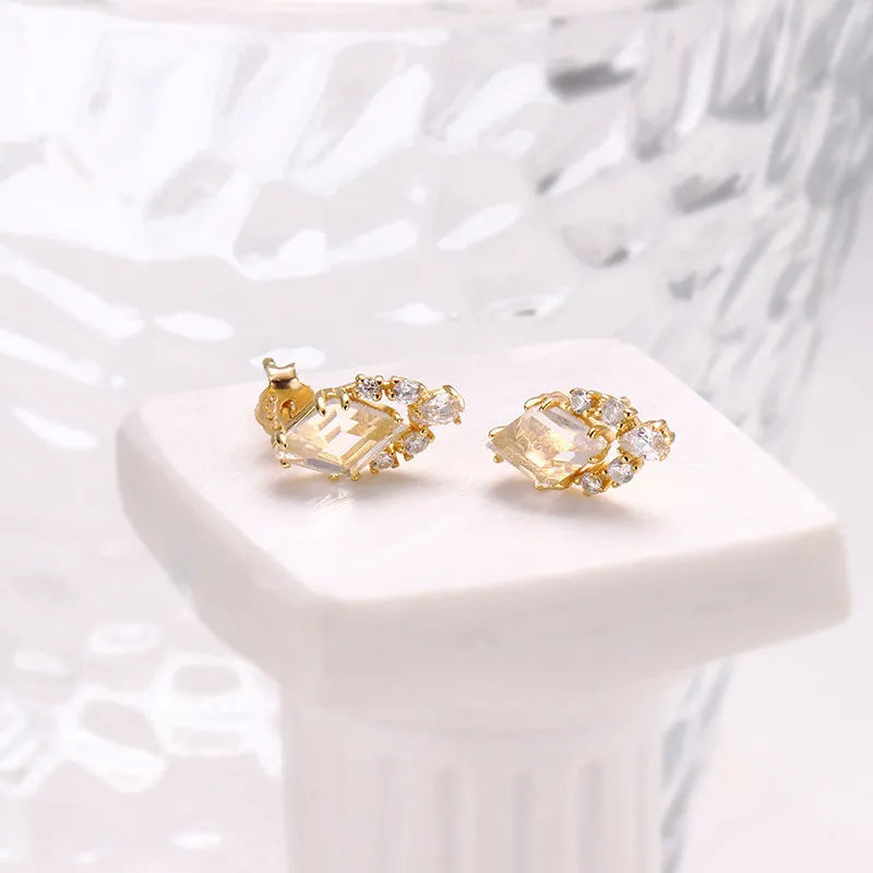 Geometric silver earrings with white crystal studs showing front detail