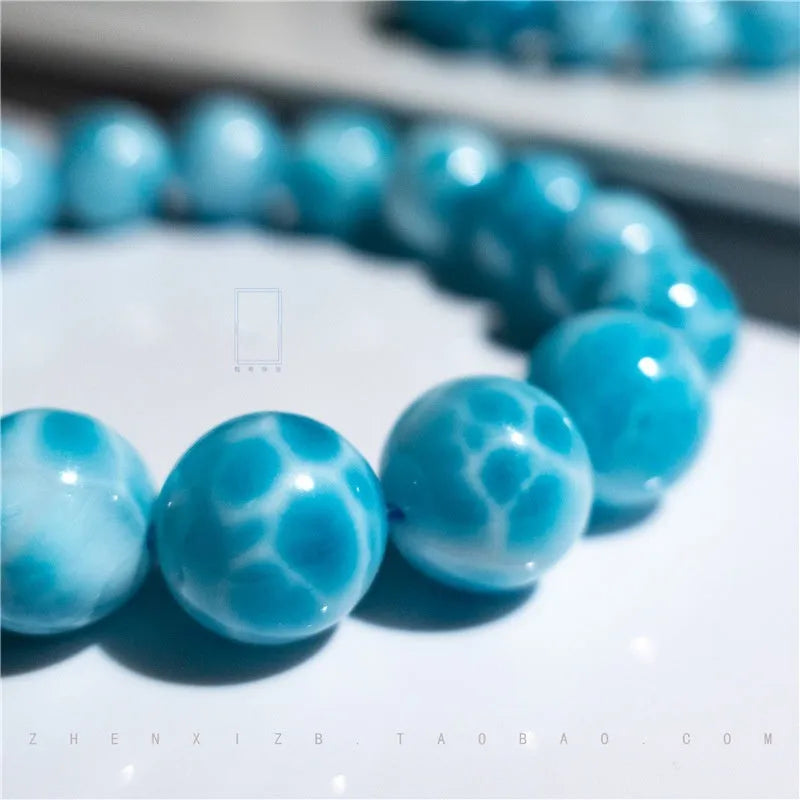 Blue bodhi bracelet with natural sea-pattern crystal stones and a single pearl bead.