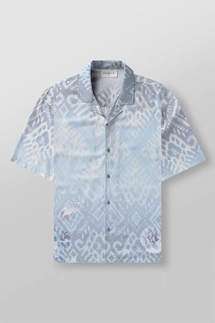 Man wearing a loose-fitting, short-sleeved printed top with a floral pattern in a neutral colour