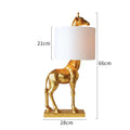 White giraffe table lamp with cloth shade on wooden bedside table