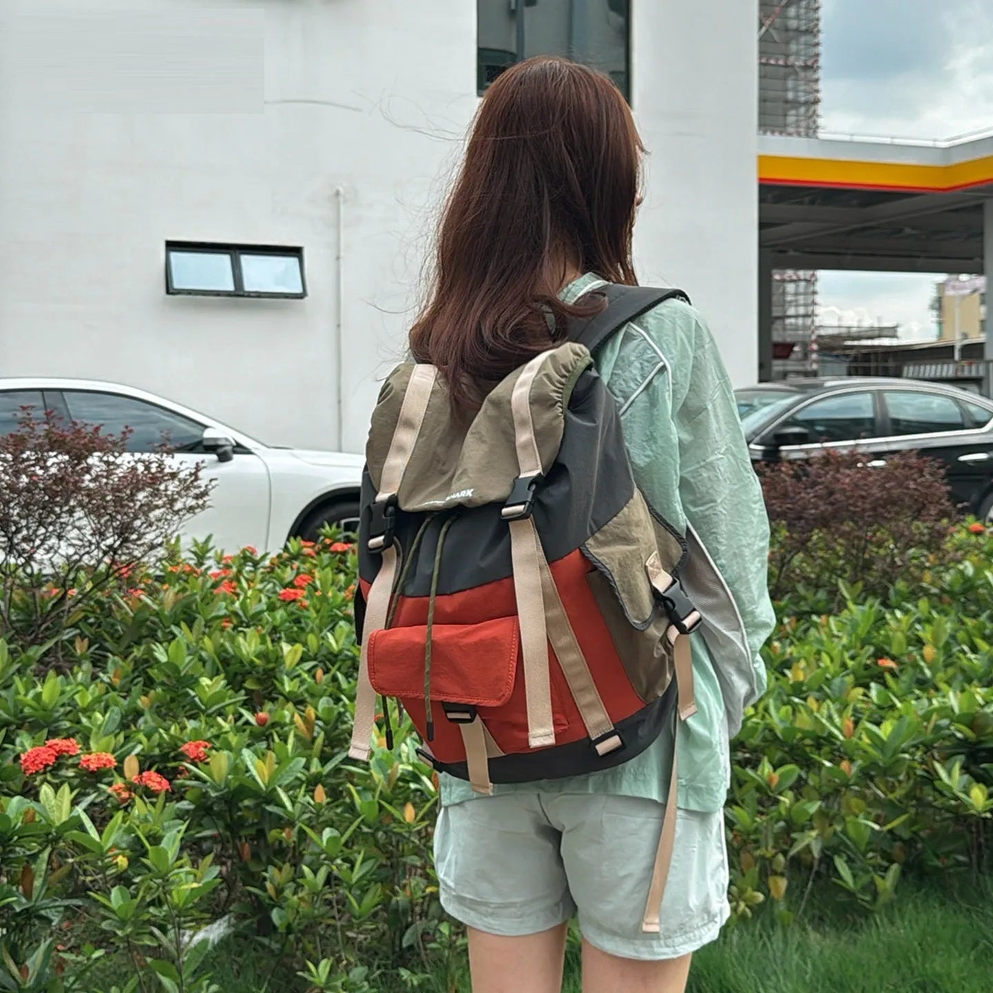 Orange green contrast colour outdoor backpack with multiple compartments and air cushion belt system.