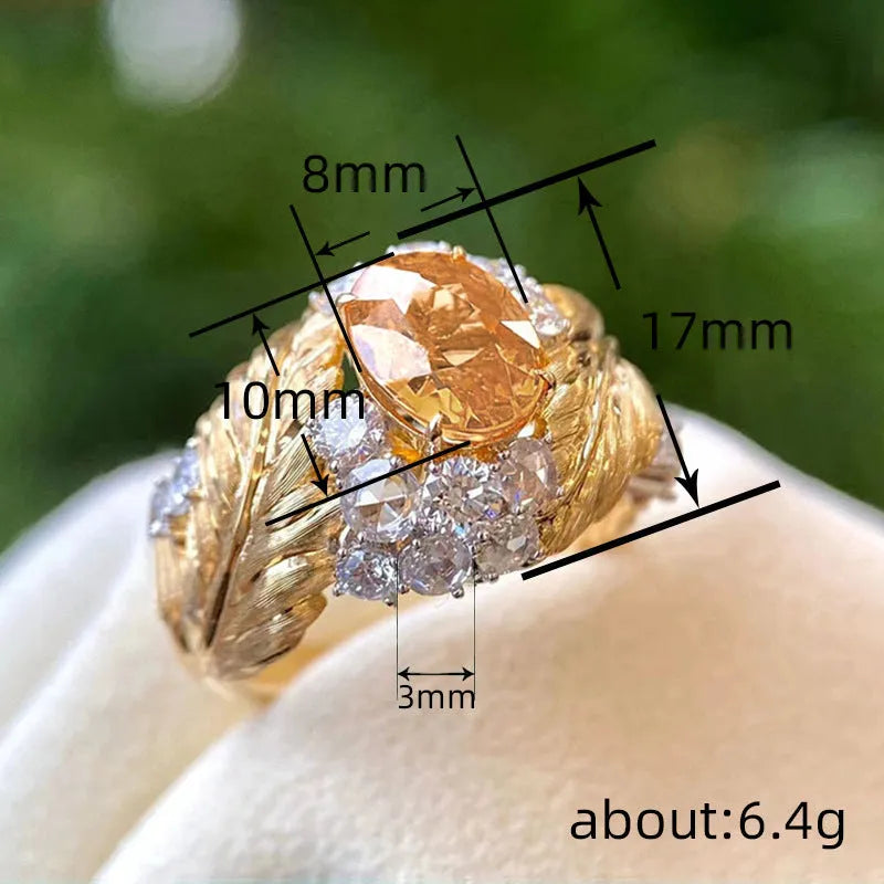 Gold-colour copper women's ring with embossed feather design and yellow zircon stone.