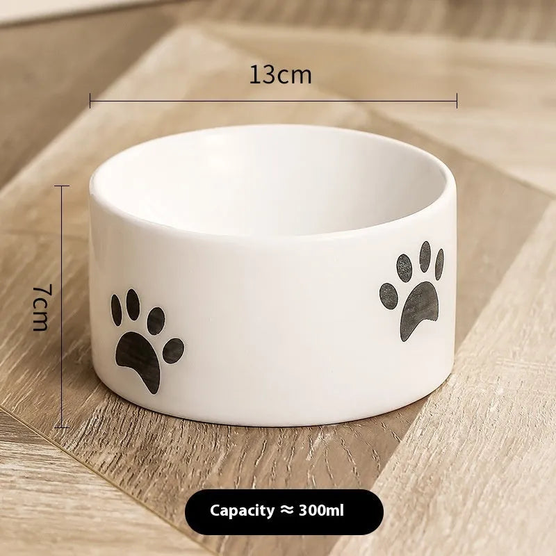 Ceramic cat bowl with cat paw design in black, showing oblique mouth style.