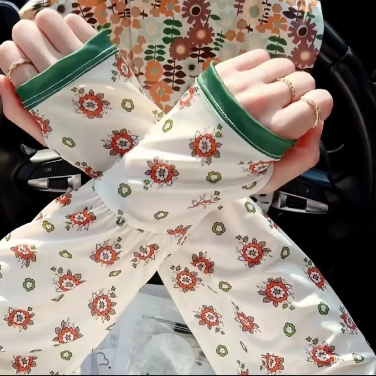 A pair of ice silk fabric oversleeves with a floral print design, shown laid flat.